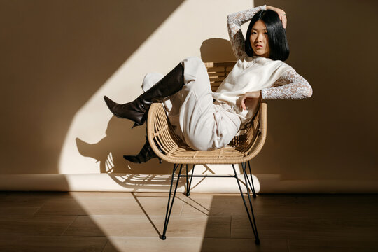 Woman in cane chair in sunlight
