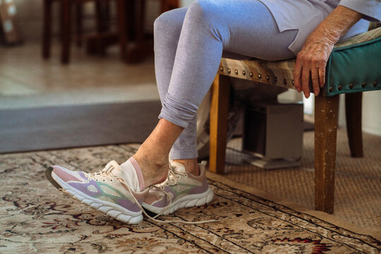 Senior Woman Takes off Athletic Shoe