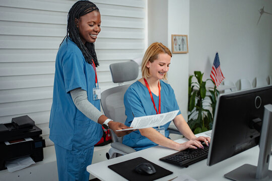Medical professionals collaborating on documents at clinic front desk