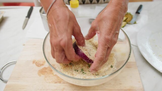 Sicilian aubergines with fresh breadcrumbs on a wooden cutting board