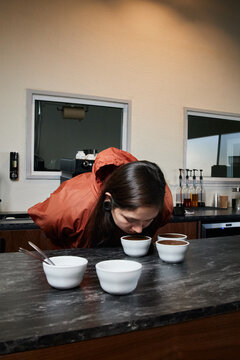 Barista Preparing Coffee Cupping with Freshly Brewed Grounds