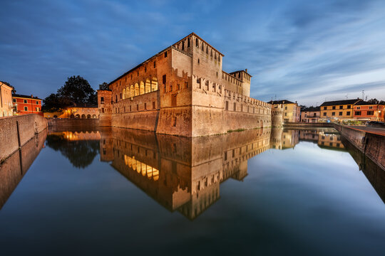 The castle of Fontanellato village reflected in the moat water taken at dusk with a cloudy sky, Fontanellato, Parma province, Emilia Romagna, Italy