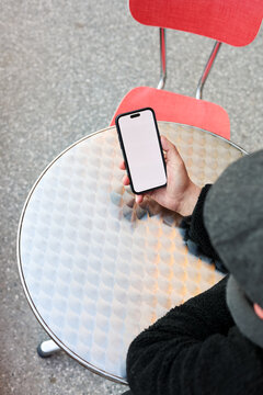 Anonymous man with a phone in cafe table 