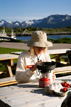 A woman cooks food in the mountains