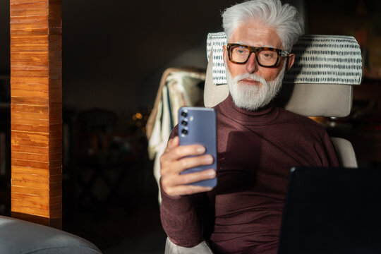 Senior Man Using Smartphone at Home