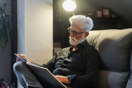 Elderly Man Reading Under Lamp Light