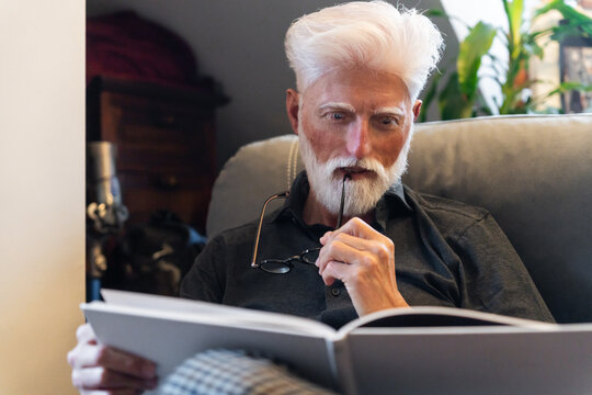 Pensive Senior Man Reading A Book