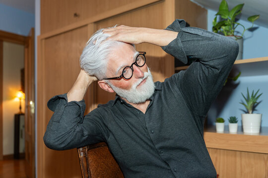 Senior Man Stretching And Relaxing At Home