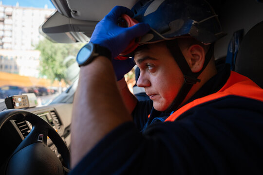 Paramedic adjusting helmet inside ambulance
