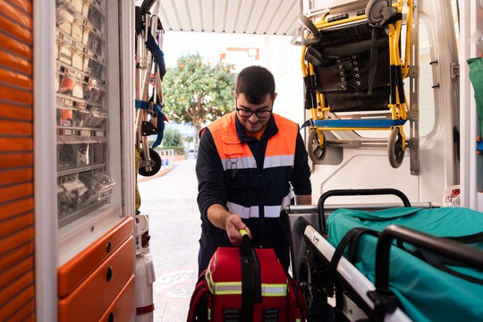 Paramedic preparing medical equipment inside ambulance