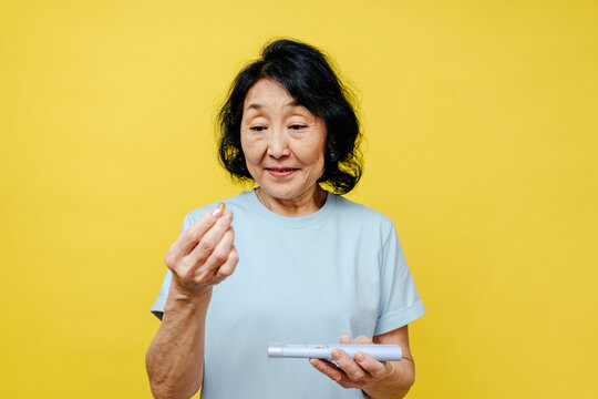 Senior Woman Holding tablet from Pillbox