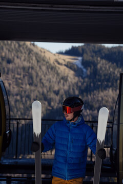One day of skier in ski resort.
The man walk near top station of lift.