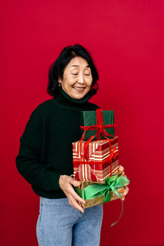 Smiling Woman with Stack of Decorated Christmas Gifts