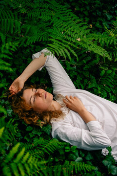 Peaceful person resting among ferns in a forest