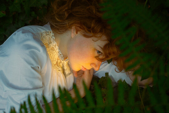 Person lying in foliage with soft golden light