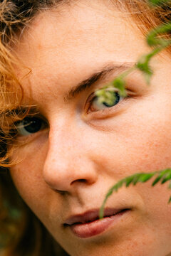 Close-up of woman's eye with greenery