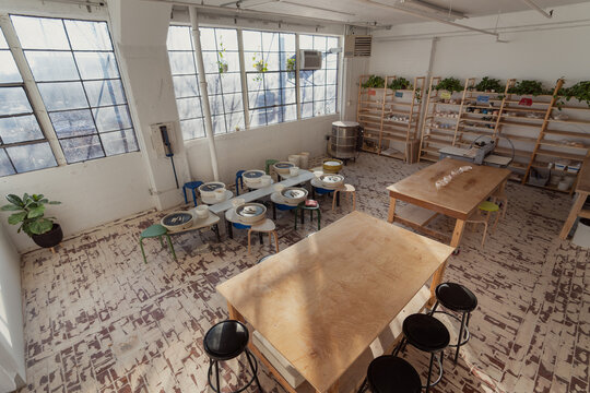 Spacious pottery studio with wheels and shelves  
