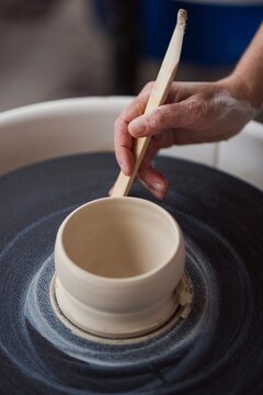 Hand shaping clay bowl on pottery wheel  
