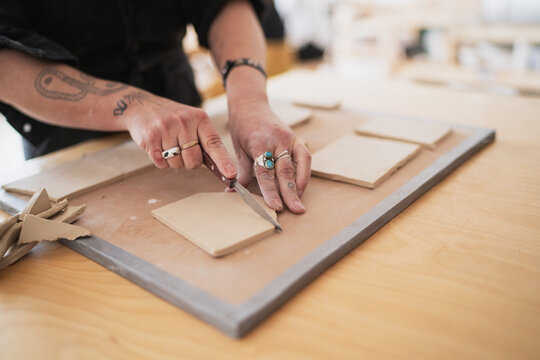 Potter cutting clay slabs for ceramics  
