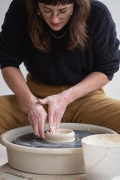 Potter shaping clay on spinning wheel

