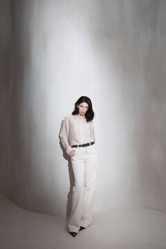 Fashion portrait of woman in neutral outfit with moody light