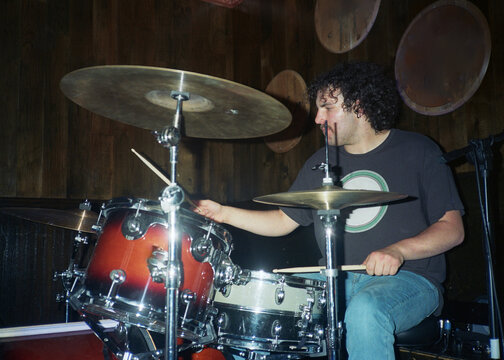 Young Man Plays the Drums at a Concert