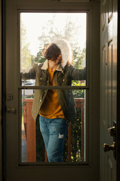 Person standing outside home backlit by Afternoon Sun