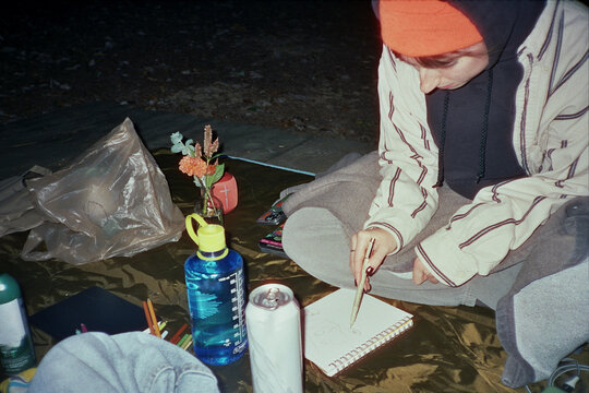 Camper Draws in Notebook at Campsite
