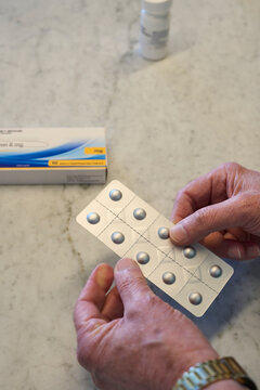Hands holding medication on a marble surface