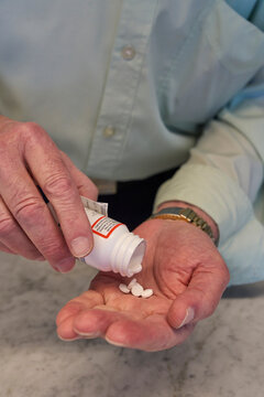 Person pouring medication into a palm in a home setting