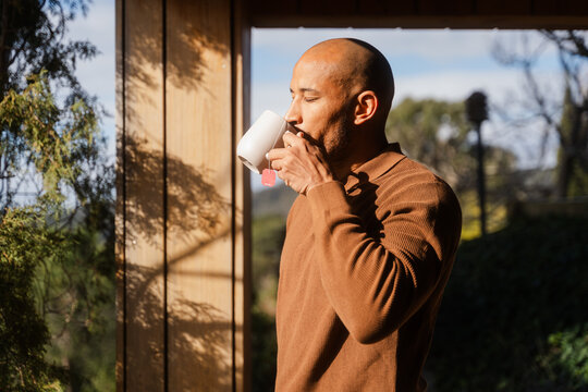 Man Enjoys Tea by Glass Window on a Bright Sunny Day