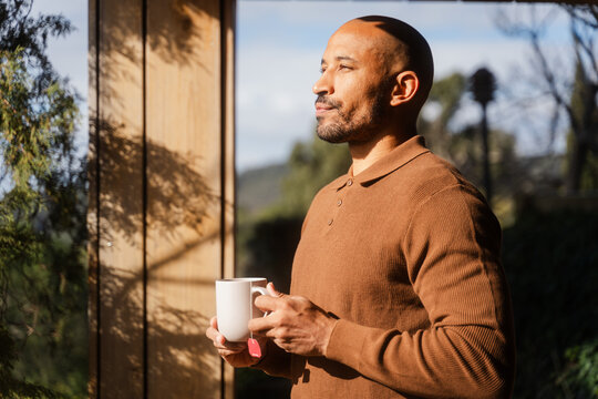 Man Savoring Tea and Sunlight by the Window in Polo Neck T-shirt