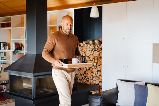 Man Carrying Breakfast Tray in Log Cabin Home