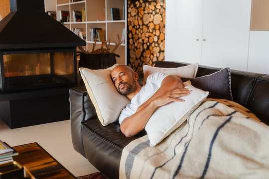 Man Enjoys Restful Nap on Sofa in Cozy Home Environment