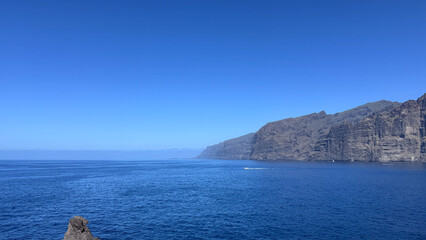 View of the blue sea and with Los Gigantes cliffs under a blue sky in Tenerife