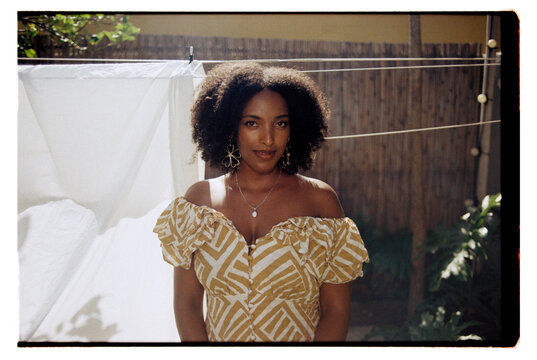 Portrait of young woman with curly hair wearing a silver necklace