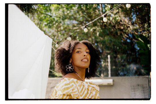Wide angle portrait of young woman with curly hair looking at camera