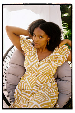 Portrait of multiracial woman sitting back in a round chair