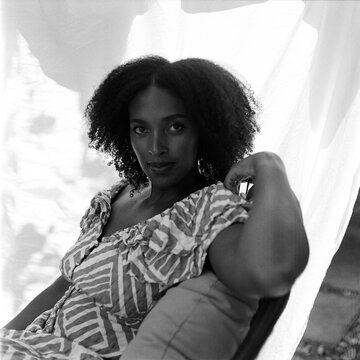 Young woman sitting in a round chair and looking back at the camera