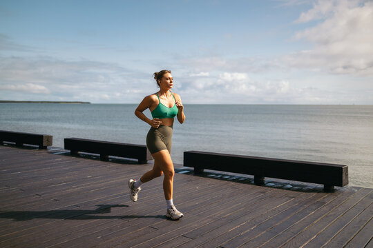 Woman running in the city next to the sea