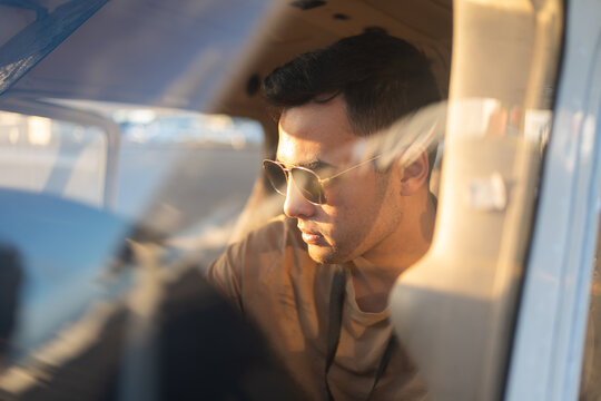 Focused Pilot Sitting in Cockpit at Golden Hour