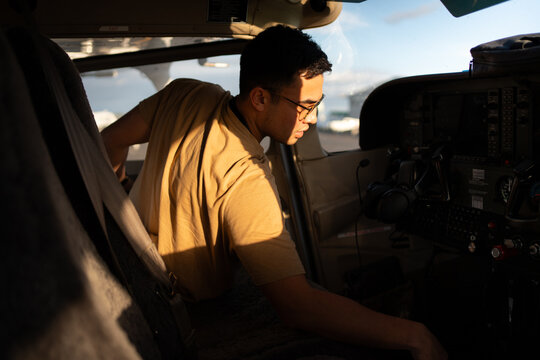 Pilot Reaching for Switches in Cockpit During Preflight Checks
