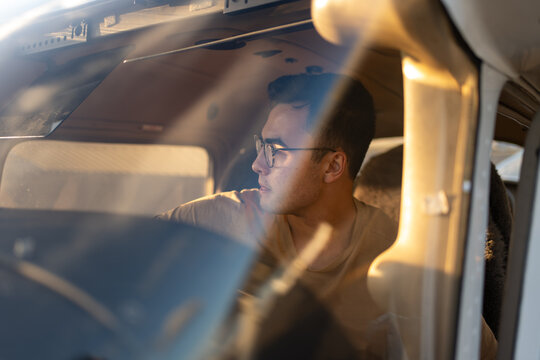 Pilot Looking Out of Cockpit Window in Warm Light