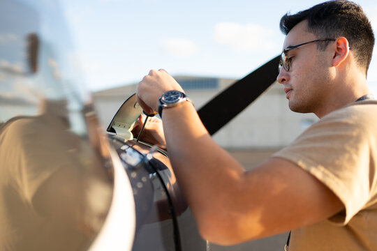 Pilot checks engine oil level as part of the preflight inspection