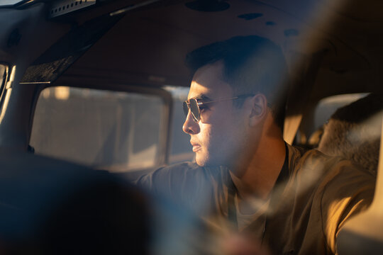 Pilot Gazing Out from Cockpit in Evening Light