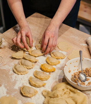 Top view of a woman's hands making dumplings