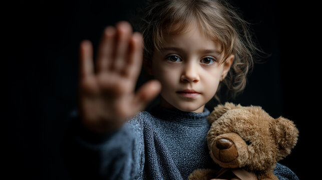 Faceless little girl holding teddy bear with hand raised in stop gesture, say no to violence and child abuse, child protection advocacy, with copy space