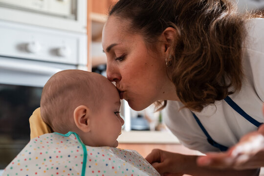 Loving mother kissing baby's forehead