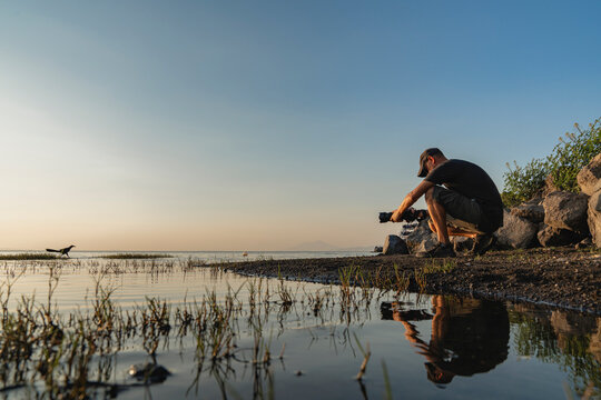 Photographer at the shore at sunrise