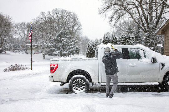 Shoveling off car on a snowy day